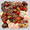 Sweet Treats board with an assortment of cookies, pretzels, strawberries, and mini brownies