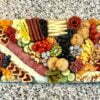 Charcuterie Traditional XL board on countertop. Mixed fruits, vegetables, meats, and nuts.