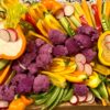 Assortment of vegetables arranged in artistic fashion on a charcuterie board.