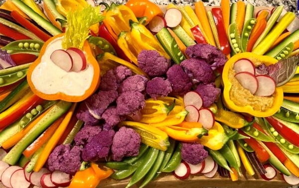 Assortment of vegetables arranged in artistic fashion on a charcuterie board.