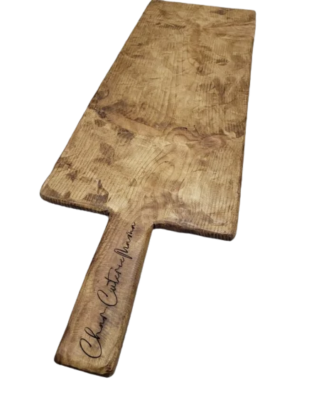 Wooden charcuterie board with the word "Char.CuterieMama" engraved in the handle.