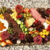Charcuterie board with assortment of meats, cheeses, fruits, and vegetables on it.