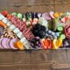 Board in traditional style with assorted meats, cheeses and fruit.