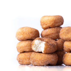 Mini donuts stacked on top of each other with a bite taken from one.