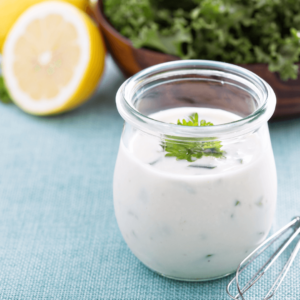 Ranch dressing within a glass container on top of a table